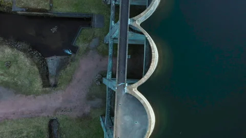 Top-down drone ascending and slowly rotating over dam, geometric aerial abstract Video stock 333179814