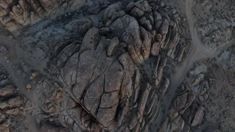 Top-Down Drone Ascends from Seated Person on Alabama Hills Granite Dome Vídeos de archivo 324323402