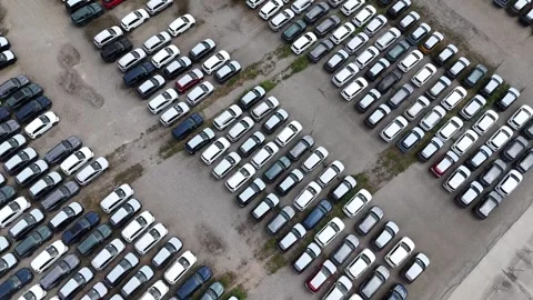 Top-down drone ascent above large automotive vehicle storage compound Stock Footage 340763131