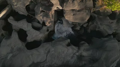 Top-down drone ascent above quartzite waterfall and plunge pool at Vale da Lua Stock Footage 341516545