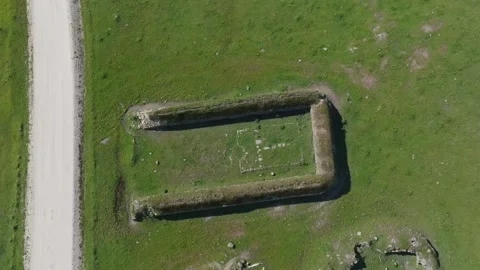 Top-down drone descent over 18th-century pig farming structure Stock Footage 308900437