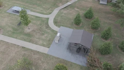 Top down drone descent over community park pavilion and pathways Stock Footage 346732561