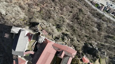 Top-Down Drone Flight Emphasizing Cliffside Monastery and Deep Ravine in Vídeo Stock 335579411