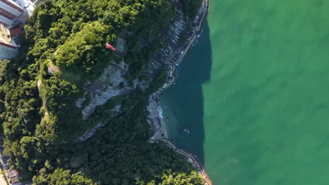 Top-down drone fly at Morro do Boi with paragliding moment under turquoise Stock Footage 317530008