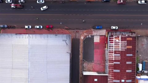 Top-down drone fly over a dual-lane avenue contrasting with a narrow alleyway Vídeo Stock 323809438