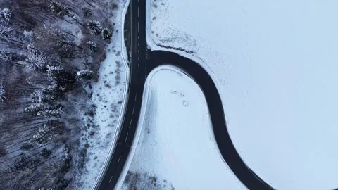 Top-Down Drone Flying Over Snowy Cliffside Road – Winter Alpine Scene 스톡 동영상 329557886