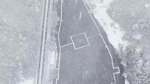 Top-Down Drone Flying Over a Snowy Road During Heavy Snowfall in Korea Stock Footage 344247951