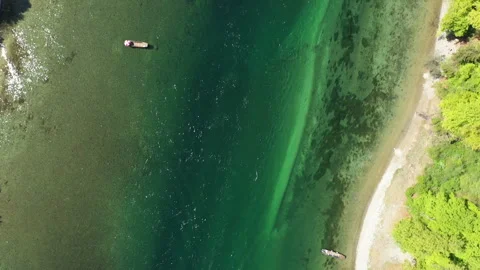 Top down drone flying towards motorboat in clear emerald river water and continu Video stock 333529450
