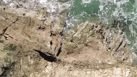 Top down drone flyover of coastal rock and breaking waves at Carlyon Bay Stock Footage 330014592