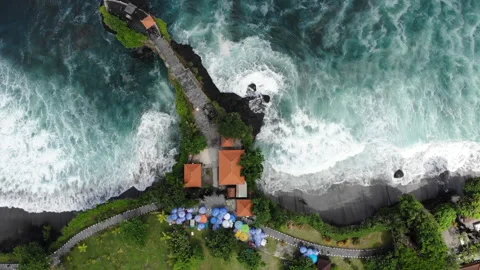 Top Down Drone Footage of Bali Coastline With Waves Cliffs and Colorful Parasols Video stock 325088593