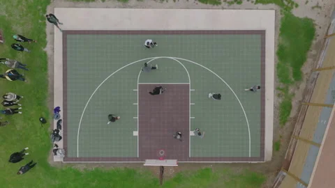 Top-down drone footage of intense basketball game on outdoor court Stock Footage 237275368