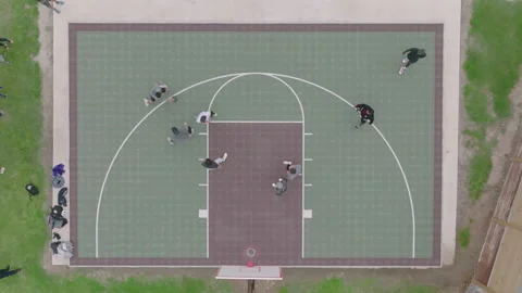 Top-down drone footage of intense basketball game on outdoor court Stock Footage 237275417