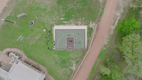 Top-down drone footage of intense basketball game on outdoor court Stock Footage 237275457