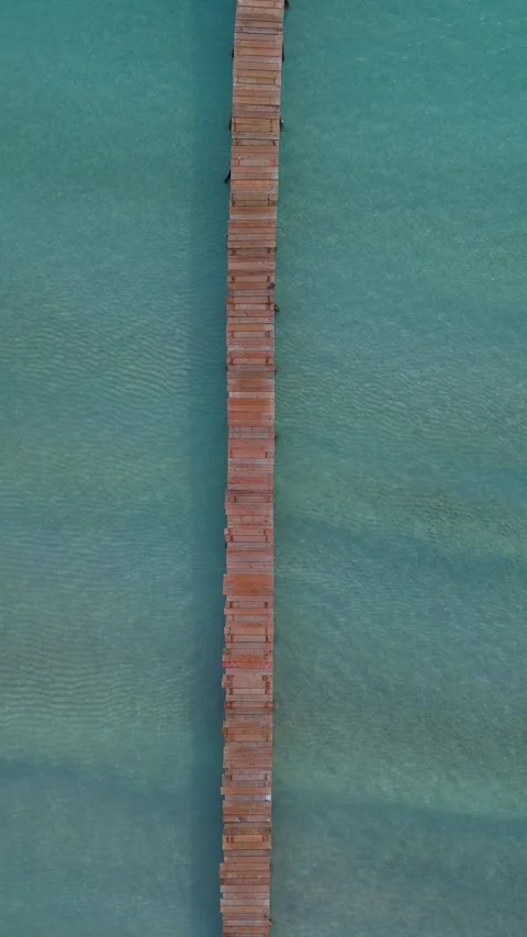Top-down drone moving over a long wooden pier at Playa de Muro, Mallorca Video stock 328336710