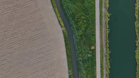 Top down drone over Idrovia canal and farmland patterns in Po Valley near Stock Footage 334712127