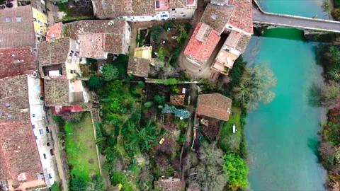 Top-down drone over trees and houses in a rural village 库存影片 347585256