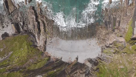 Top-down drone pull-out of waves lapping against the rocky North Atlantic Stock Footage 279957672