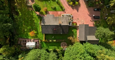 Top down drone shot above house with a person washing the roof, fall in Finland Vídeo Stock 323375621