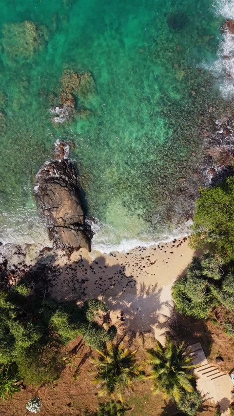 Top down drone shot of beach with rocks in the jungle Stock Footage 331026745
