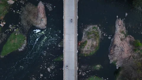 Top Down drone shot of a bridge cutting across a river in rural India Stock Footage 305259237