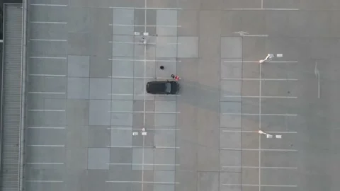 Top-down drone shot of a car on an empty parking deck Stock Footage 194999130