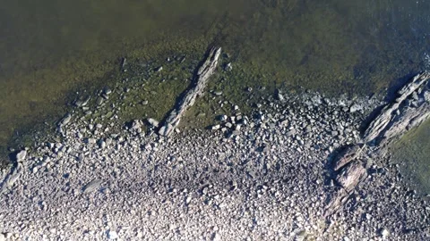 Top-down drone shot of coastal rocks and shallow waters in Montevideo Stock Footage 310140818