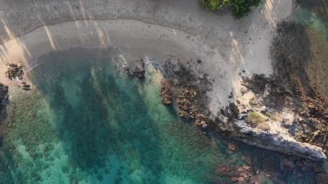 Top Down Drone Shot of Coastal Cliff and Clear Ocean Water with Tropical Be.. Video stock 332966738