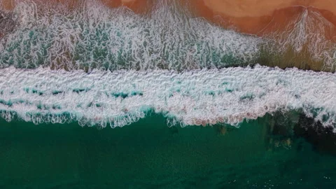 Top-Down Drone Shot Descending Toward Ocean Waves Breaking Along Shore Stock Footage 325696208