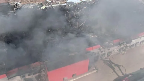 Top-down drone shot of destroyed burning plant with smoke clouds. Stock Footage 210109904