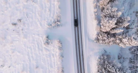 Top down drone shot of a EV car in middle of snowy trees, winter in Lapland Stock Footage 295280068