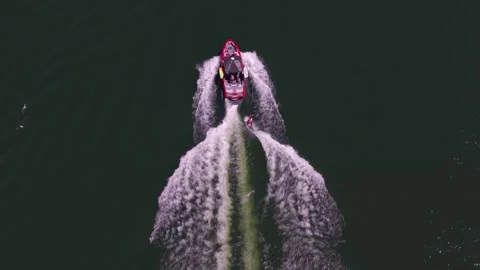 Top-down drone shot following a speedboat pulling a wakeboarder Stock Footage 339505959