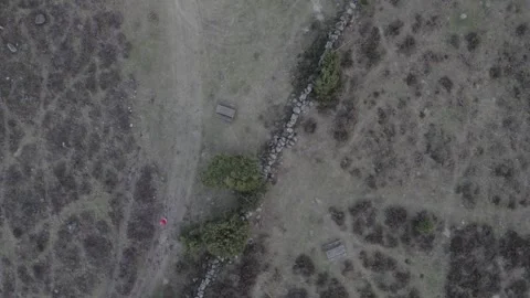 Top down drone shot of hiker in a red jacket 스톡 동영상 321801925