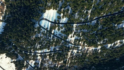 Top down drone shot of mountain serpentine road in winter forest Vídeos de archivo 326220550