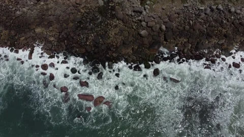 Top-down drone shot of ocean waves crashing on rocks Stock-Footage 320568827