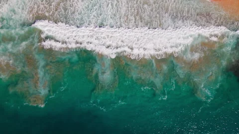 Top-Down Drone Shot of Ocean Wave Breaking Over Shallow Water and Sand Stock Footage 325696382