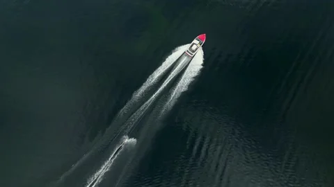 Top down drone shot of a person riding a trick ski behind a ski boat on a Vidéo 233963735