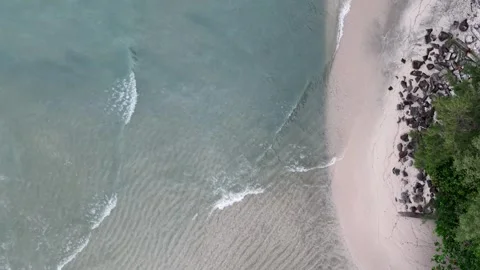Top-down drone shot of pristine beach meeting turquoise waters Video stock 345835253