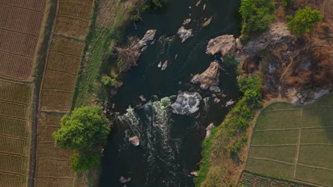 Top down Drone shot of a river flowing in between fields in rural India Stock Footage 305268270
