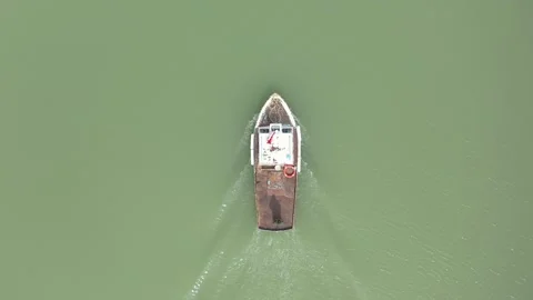 Top Down Drone Shot Of Small Fishing Boat Moving On Green Lake Water Stock Footage 324695882