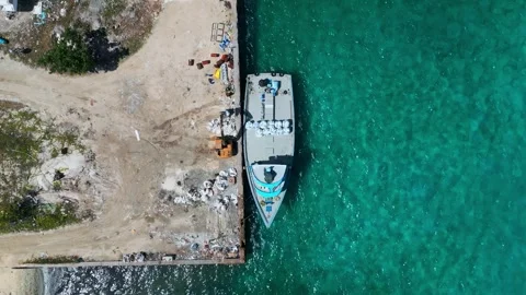 Top down drone shot of speedboat docked at tropical island concrete wharf 库存影片 347585462
