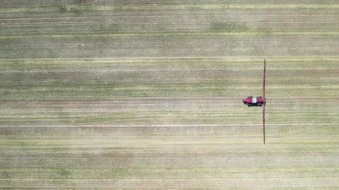 Top Down Drone Shot of Tractor Sprayer Crossing Patterned Farm Rows Видео 336129293