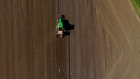 Top down drone shot of a tractor working a feild Stock Footage 343410743