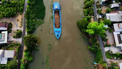 Top-down drone shot of a traditional cargo boat navigating a muddy river Vídeos de archivo 336040658