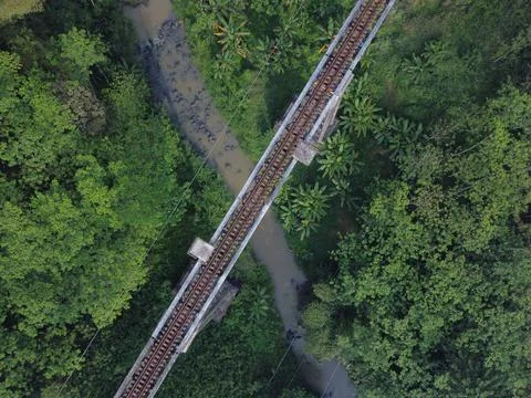 Top down drone shot of Train Bridge crossing a river in Indonesia on a morning Stock Photos