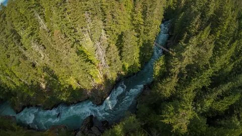 Top down drone shot of turquoise river canyon rapids and a wooden footbridge Stock-Fotos