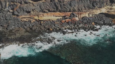 Top Down Drone Shot of Waves Crashing on Rocky Coastline Stock Footage 326202430