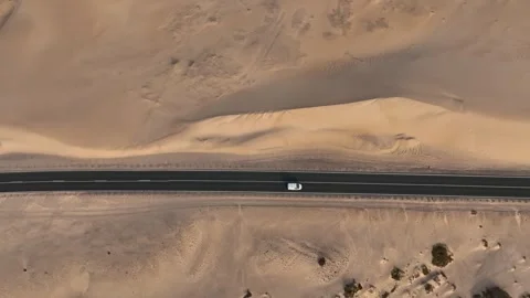 Top down drone shot of white car driving a desert road Stock Footage 343622266