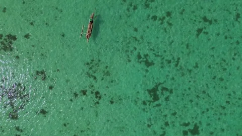 Top Down Drone Shot of Wooden Boat Gliding on Clear Turquoise Ocean Vídeos de archivo 345986927