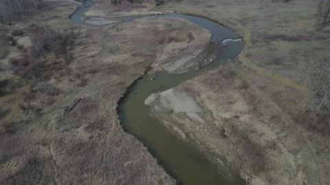 Top down from drone showing small creek and tilting up to neighborhood Stockbeeldmateriaal 167564517