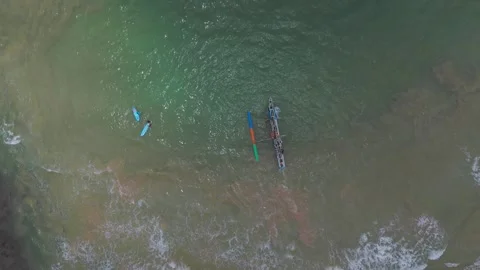 Top-Down Drone Tracking of Fishing Boat and Surfers on Tropical Coastline Stock Footage 319918670